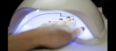 Manicured hands under UV Lamp